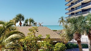 A beachfront hotel with a palm tree-covered roof and a view of the ocean. - Gulf Views From Every Room! Heated Pool. Direct Beach Access.  Recreation Room. Beautiful Beach. (Treasure Island)