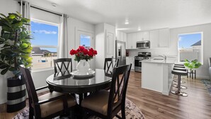 A modern kitchen with white cabinets, stainless steel appliances, and a central island.