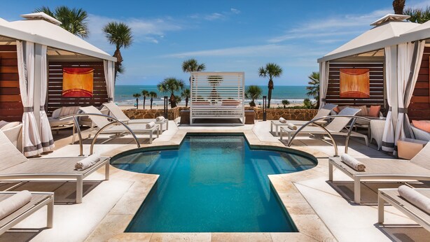 A pool area with lounge chairs and a view of the ocean. - San Luis Beauty in The Beautiful San Luis Resort Pet Friendly (Galveston)