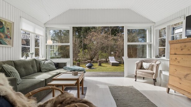 A spacious living area with a large window, a sofa, a chair, and a wooden cabinet. - "Lucie" - 50m from the sea by Interhome (Rønne)