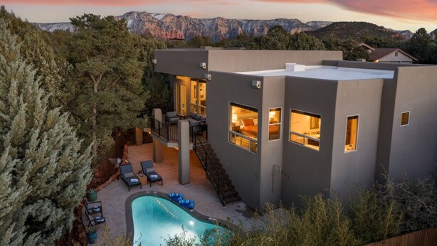 A modern house with a pool, outdoor seating, and a view of mountains. - Two Custom Homes with Pool, Spa, Rooftop Deck (Sedona)