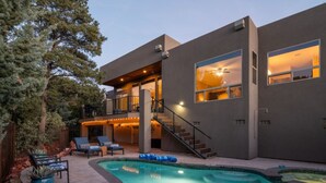 A modern two-story house with a swimming pool, outdoor seating, and a staircase leading to the upper level. - Two Custom Homes with Pool, Spa, Rooftop Deck (Sedona)