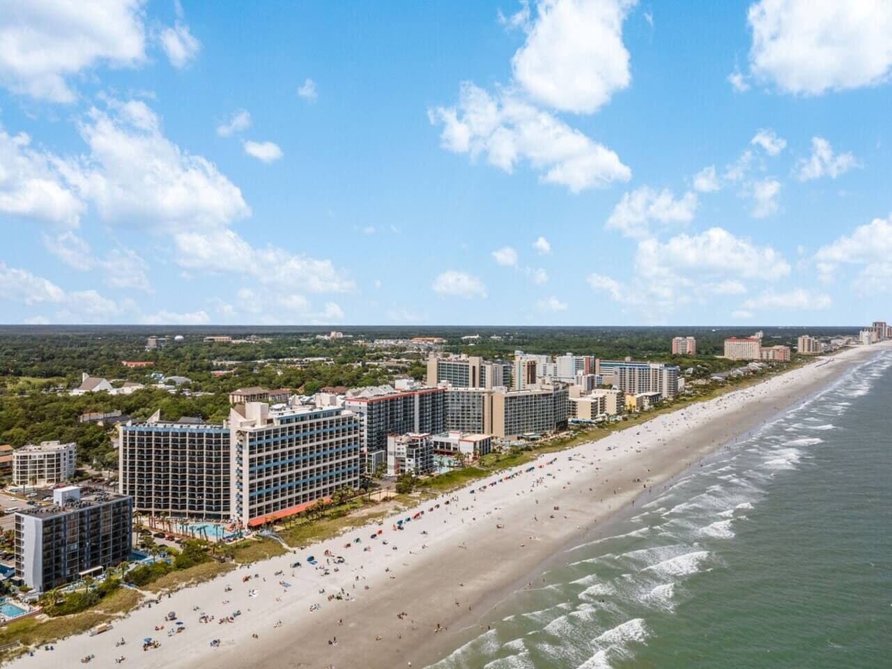 A coastal hotel with multiple buildings, a beach, and ocean views.