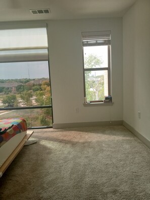 Enjoy a peaceful view of the surrounding neighborhood from the large window in this cozy room.