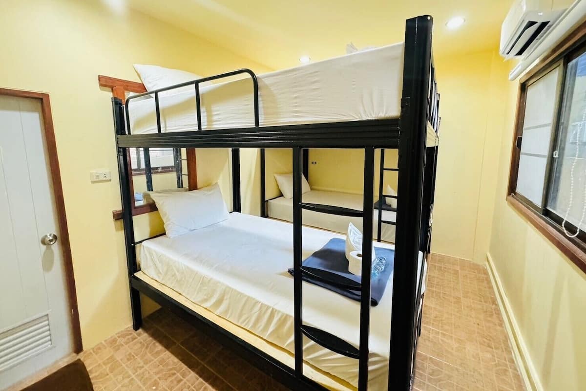 Quarto com beliche, janela e ar condicionado.