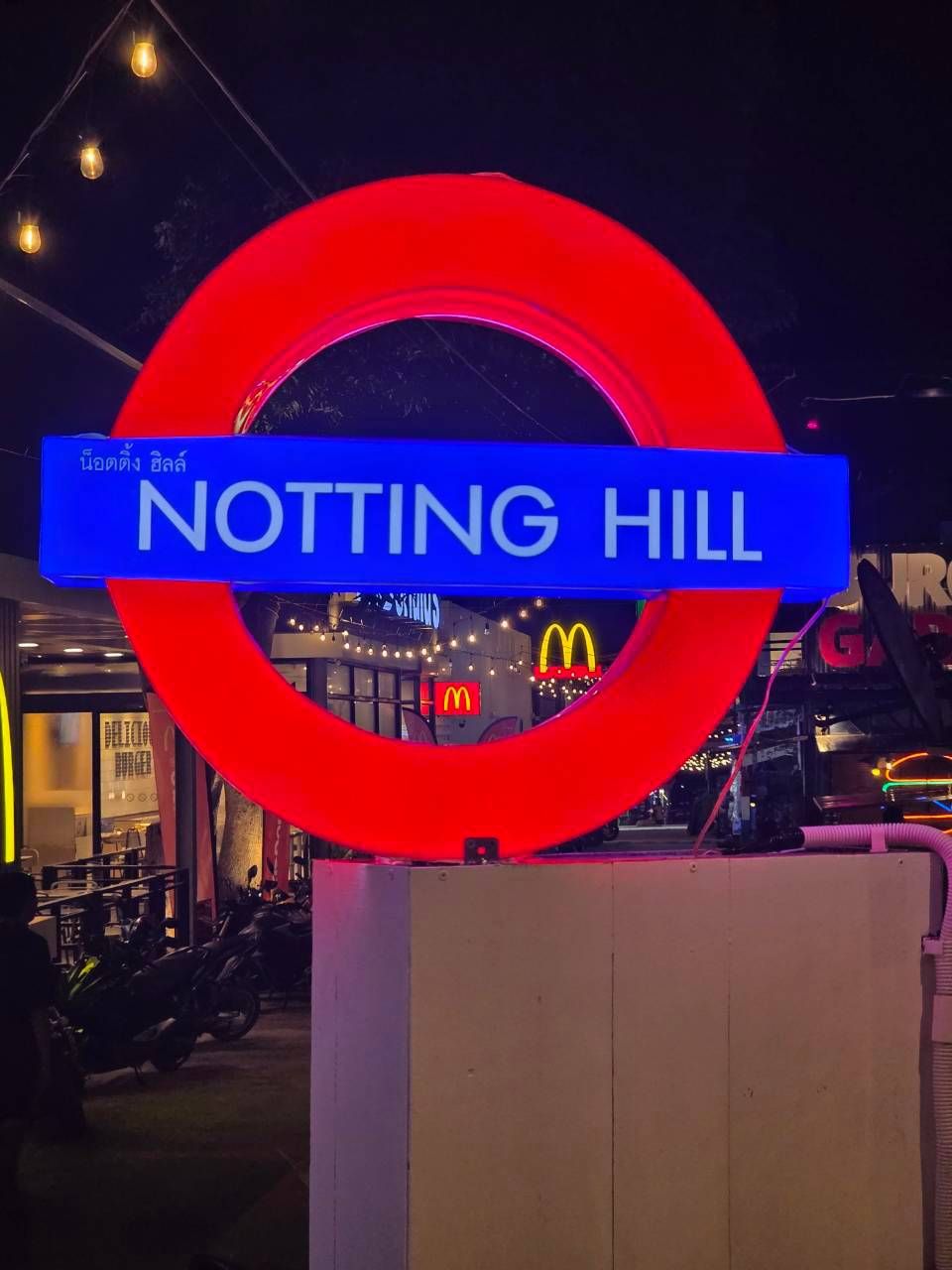 Letrero de Notting Hill con un diseño circular rojo y un banner azul.