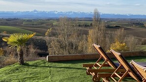 Vista d'un balcó amb vista a un paisatge de muntanyes sota un cel serè.