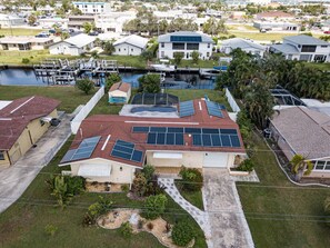 Un quartier résidentiel avec une maison dotée d’un toit rouge et de panneaux solaires.