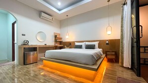 A modern bedroom with a skylight, a built-in desk, a bed with a headboard, and a small kitchenette. - Dara Homestay Koh Kood (Ko Kood)