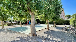 Ein Park mit Bäumen, einem Spielplatz und Fahrrädern.