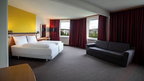 A hotel room with a bed, a sofa, a desk, and a window with curtains. - Best Western Conference Airporthotel Frankfurt Mörfelden (Moerfelden-Walldorf)