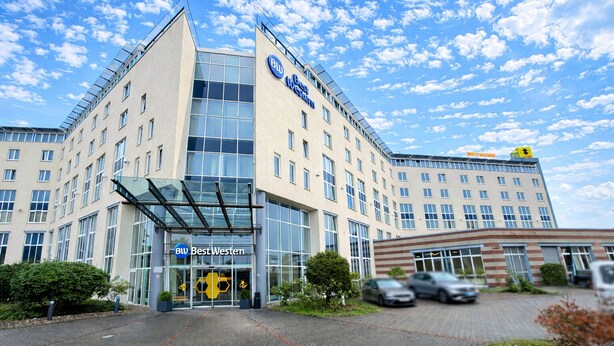 A modern hotel with a glass facade, labeled "Best Western," featuring a prominent entrance and a parking area. - Best Western Conference Airporthotel Frankfurt Mörfelden (Moerfelden-Walldorf)