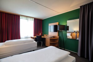 A hotel room with two beds, a desk, a chair, a TV, and a mirror. - Best Western Conference Airporthotel Frankfurt Mörfelden (Moerfelden-Walldorf)