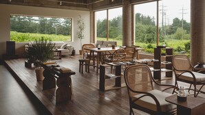 A spacious room with large windows, a wooden table, and comfortable seating. - uonstay (Gyeongju)