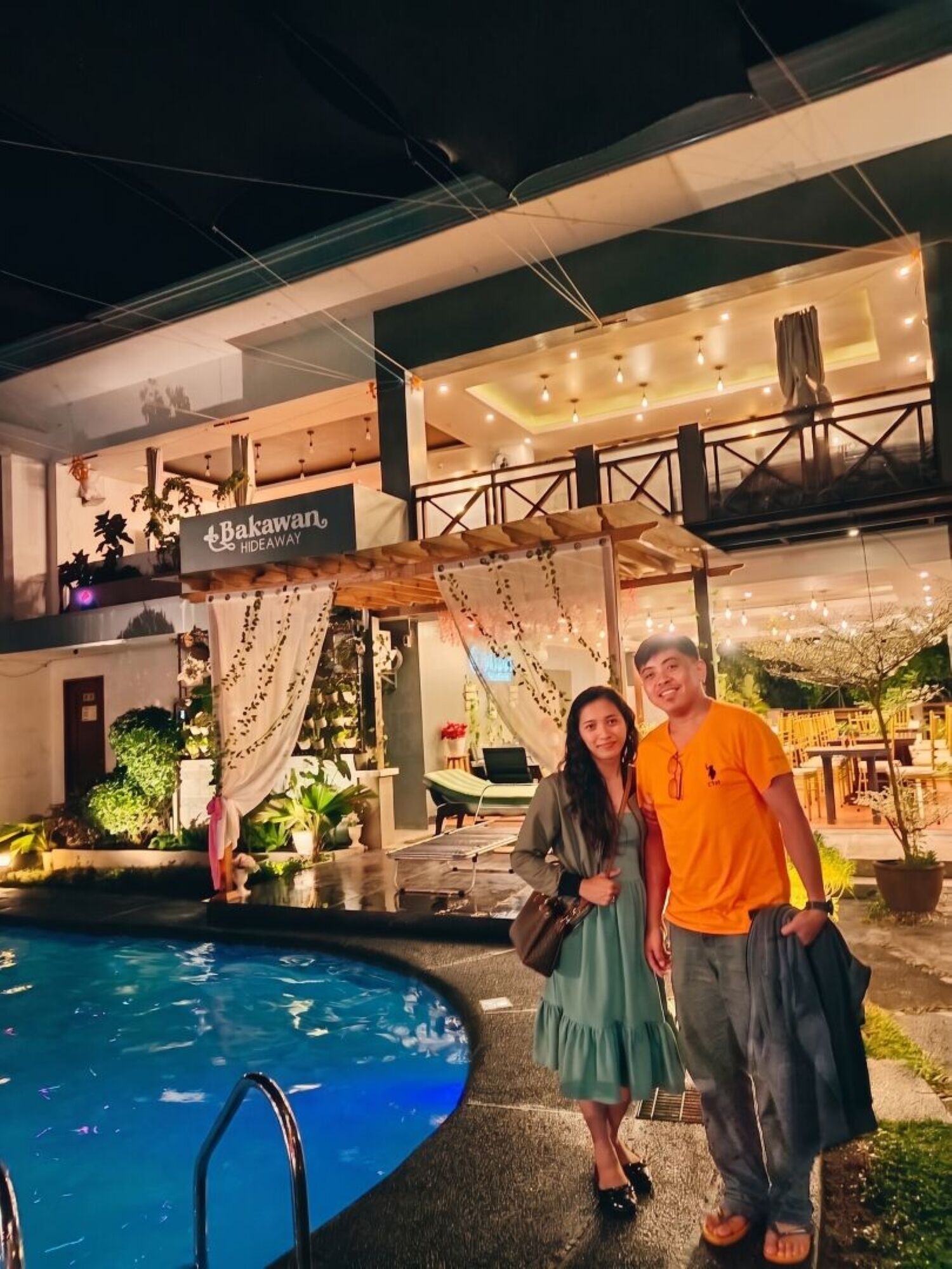A two-story building with a pool, outdoor seating, and a sign reading 'Bakawan Hilldeaway.'