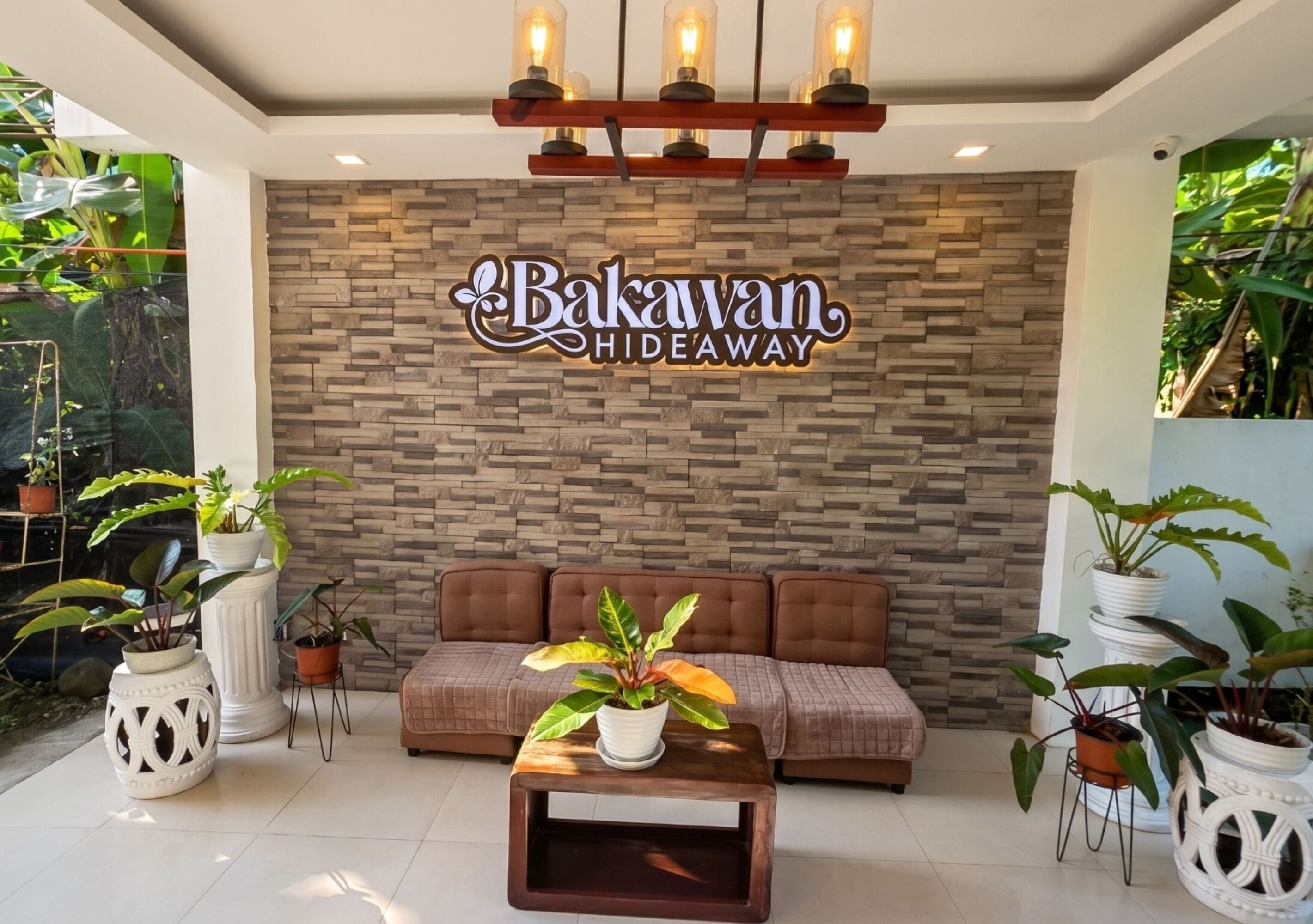 A modern interior with a stone wall, a brown sofa, and potted plants.