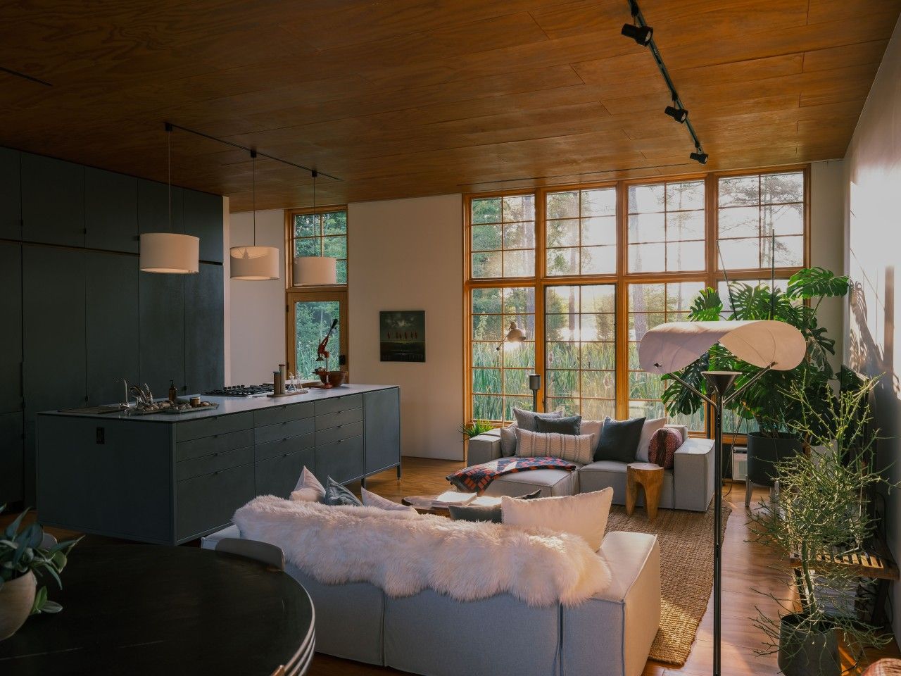 A modern interior with a kitchen island, seating area, and large windows.