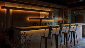 A bar area with wooden paneling, hanging lights, and bar stools. - 3U NAMBA MINAMI - DOYANEN HOTELS (Osaka)
