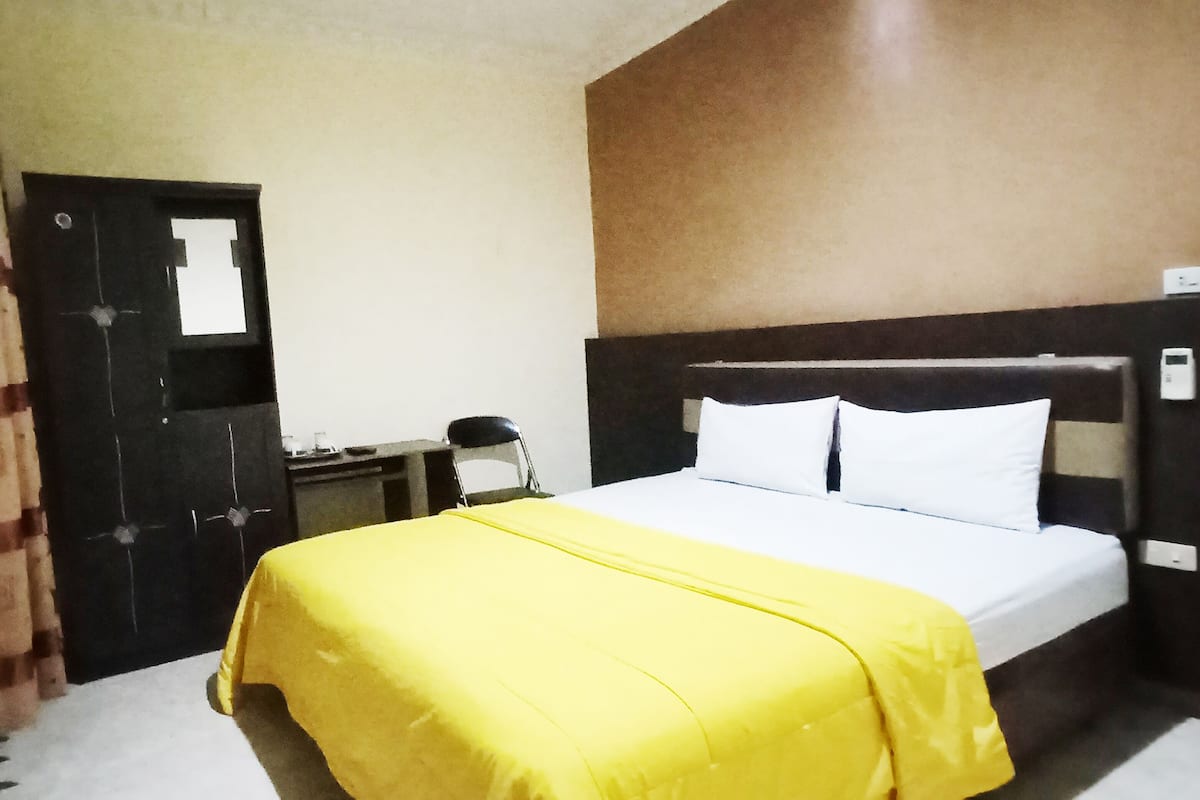 Ein Hotelzimmer mit Bett, Nachttisch und Tür.