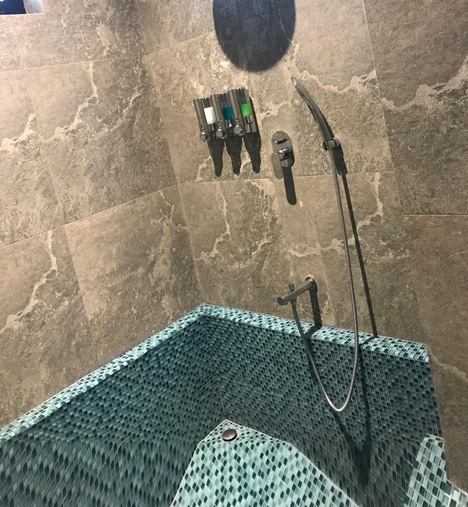Une salle de bain avec une douche, un porte-serviettes et des toilettes.