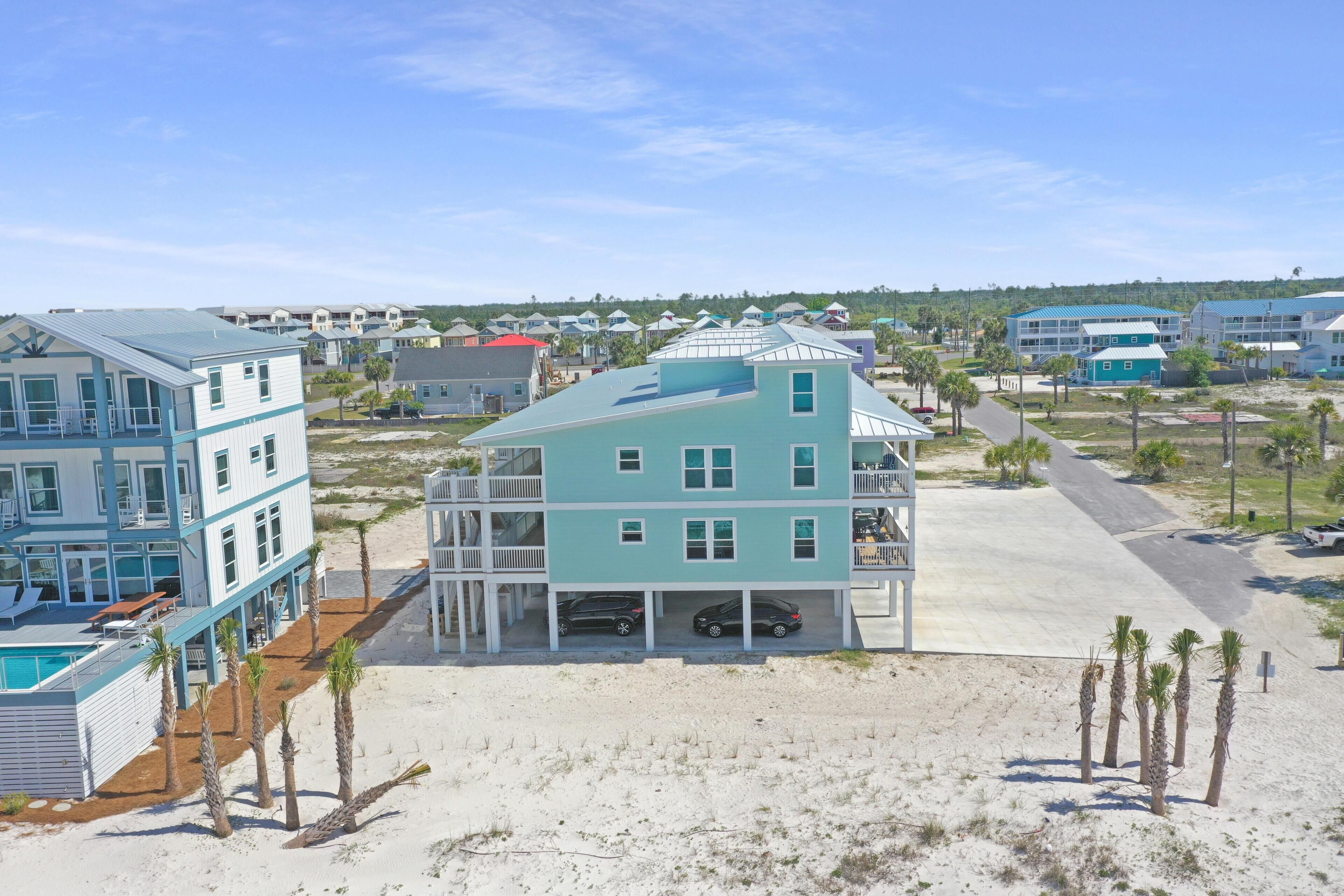 Une propriété située en bord de mer, comprenant une grande maison dotée d’un porche couvert et d’une piscine.