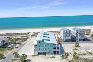 A beachfront hotel with multiple buildings, a sandy beach, and the ocean in the background.