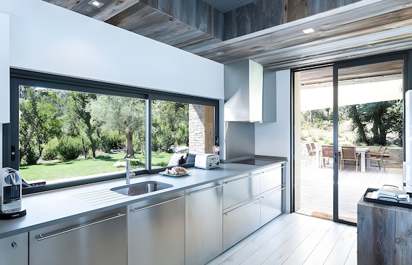 Eine moderne Küche mit einem großen Fenster, einem Toaster und einem Spülbecken.