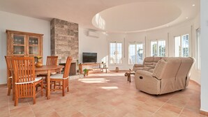 A spacious living area with a dining table, chairs, a sofa, and a television. - Holiday Home 'Tower House' with Sea View, Wi-Fi and Air Conditioning (Competa)