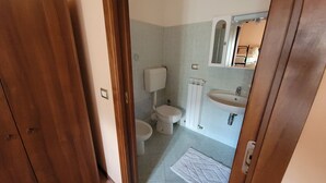 Un baño con inodoro, lavabo y espejo.