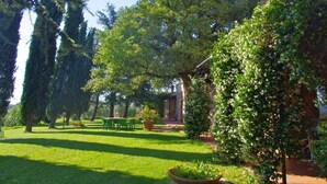 Ein Garten mit Rasenfläche, Bäumen und Gartenmöbeln.