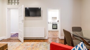 A modern apartment with a dining area, a kitchen, and a living room.