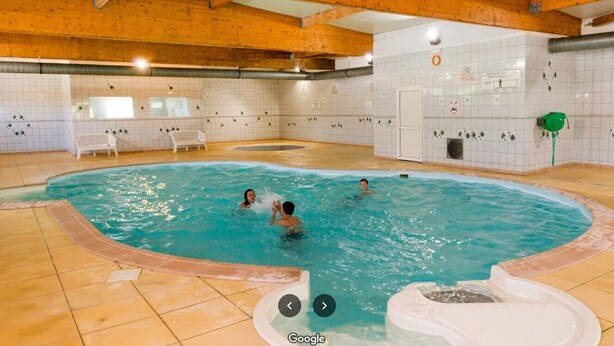 An indoor swimming pool with wooden beams, tiled walls, and a tiled floor. - Mobilhome Nicolette, 15 Minutes de Europa-park! (Boofzheim)