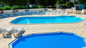 A swimming pool with multiple lounge chairs and a tiled deck. - Mobilhome Nicolette, 15 Minutes de Europa-park! (Boofzheim)