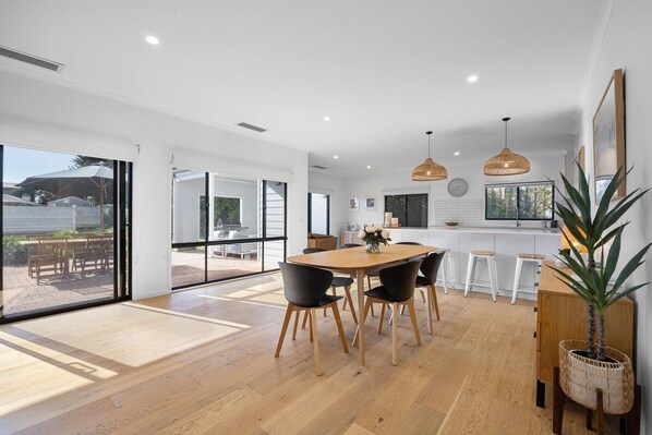 Una cocina moderna con comedor, ventanas amplias y vistas al exterior.