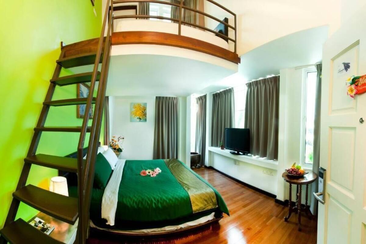 A bedroom with a bunk bed, a TV, a window with curtains, and a door with a sign.