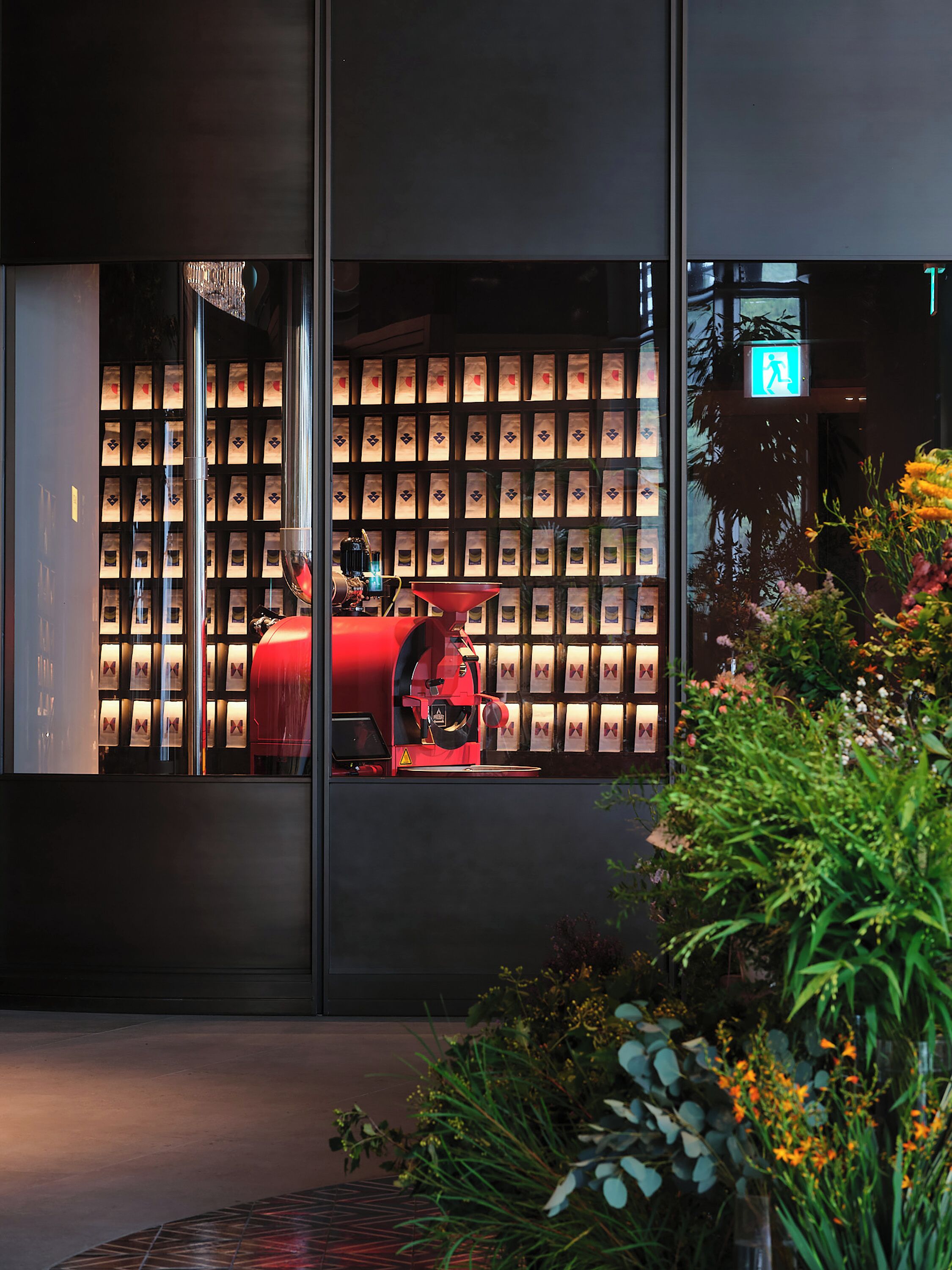 A modern building facade with a coffee machine and a wall of coffee bags.
