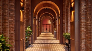 A brick-walled hallway with arched ceilings and patterned flooring. - Ananti At Busan Village (Busan)