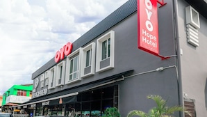 A hotel named 'OYO Hope Hotel' with a modern facade, large windows, and a prominent red sign. - Hope Hotel (Masai)
