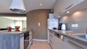 A modern kitchen with a curved island, built-in appliances, and a pendant light. - Charming renovated apartment for 4 with terrace in Hunawihr (Hunawihr)