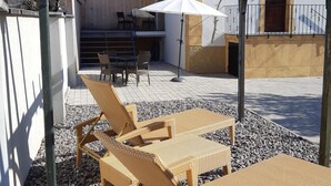 A patio with wicker furniture, a white umbrella, and a dining area with chairs and a table. - Cozy Alsace Retreat: 2BR, Sauna, Pool Access, Near Vineyards & Colmar (Rouffach)