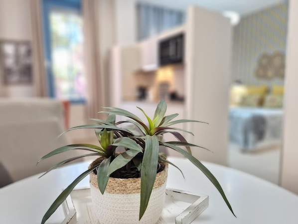 Une plante en pot est posée sur une table blanche dans une pièce au décor moderne.
