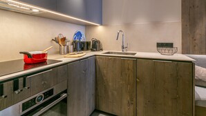 Una cocina moderna con horno integrado, un lavamanos y armarios de madera.