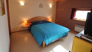 A bedroom with a bed, bedside lamps, a window, and a wooden ceiling. - Charming Alsatian Farmhouse: 2 Terraces, BBQ, Accessible, Near Vosges – Sleeps 6 (Bretten)