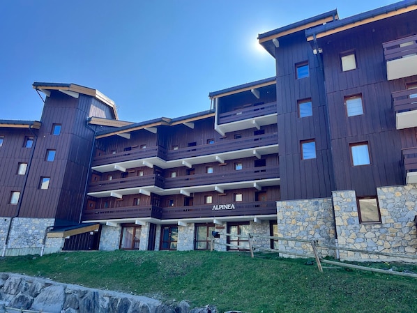 Un hôtel à plusieurs étages, doté d’une façade en pierre et de balcons.