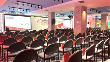 A conference room with rows of chairs and a presentation screen displaying 'MEDICA UPDATE'.