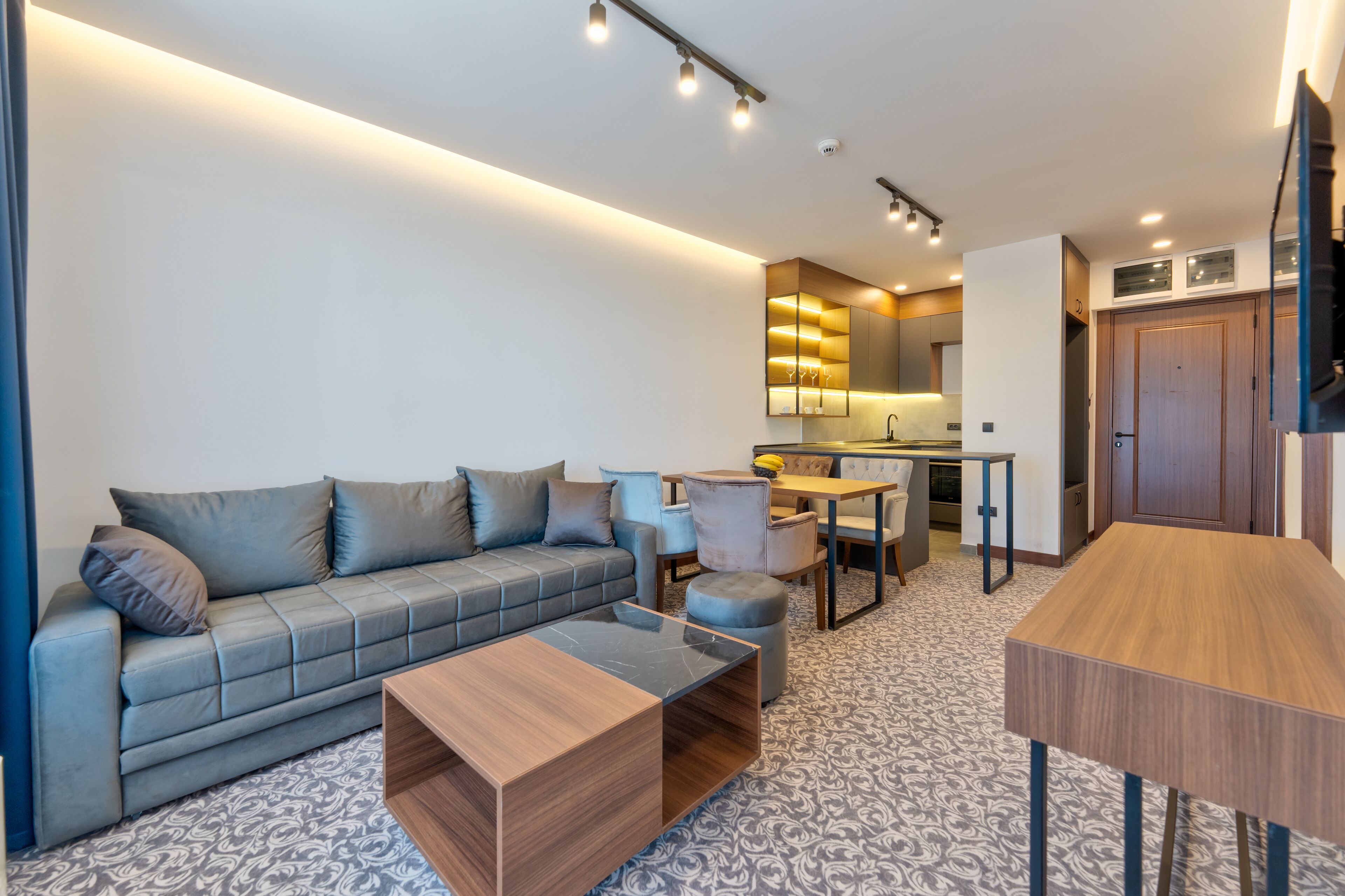 Una sala moderna con sofá, mesa de centro y un comedor con sillas y mesa.