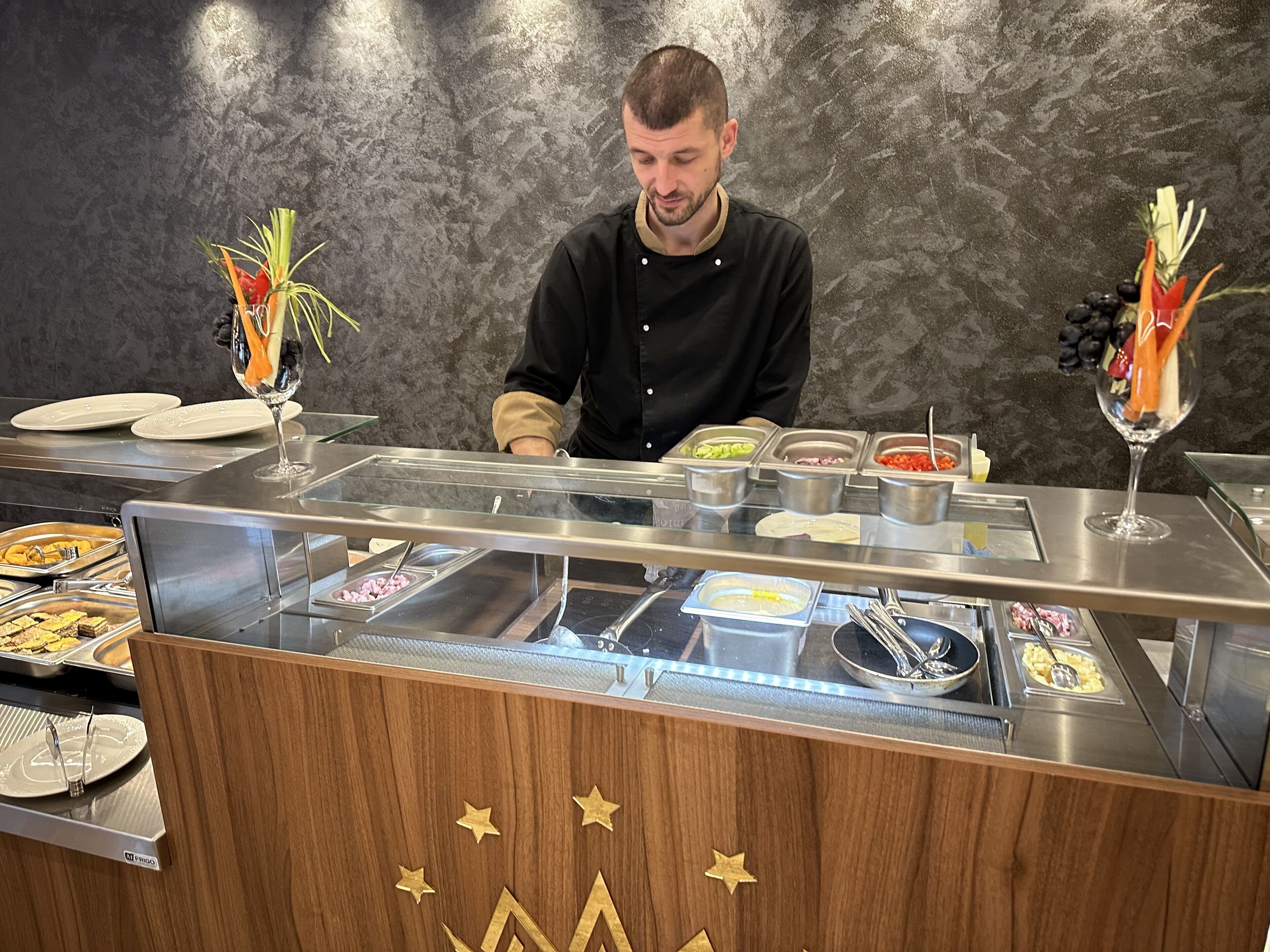 Zona de bufé con diversas opciones de comida y un barman.