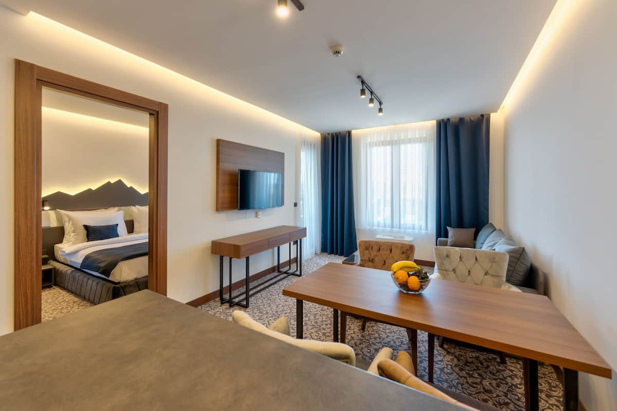 Une chambre d’hôtel moderne équipée d’un lit, d’un bureau, d’une table à manger et d’un canapé.