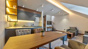 A modern living space with a dining area, kitchen, and seating area.