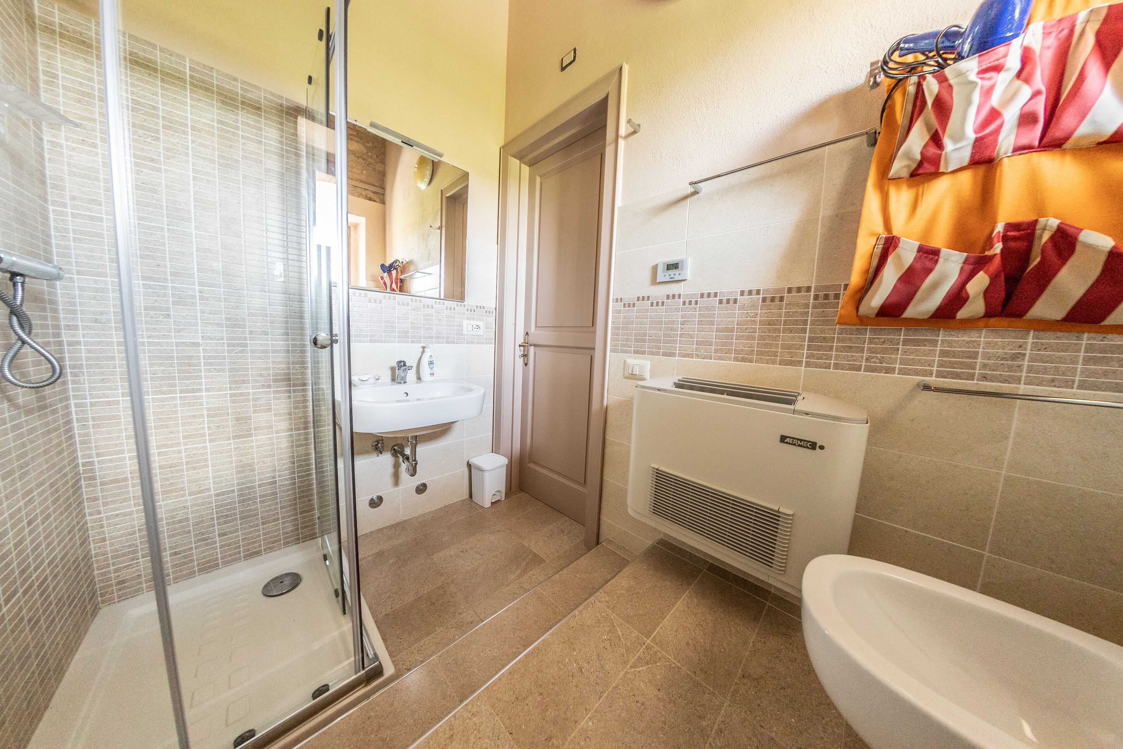 A bathroom with a glass shower enclosure, a sink, a toilet, and a bathtub.